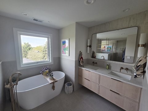 Bathroom remodel with charcoal vanity and brass fixtures by MDR Design-Build-Remodel